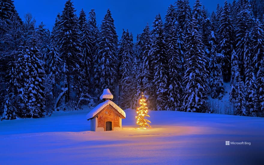 Snowy chapel with Christmas tree in the Bavarian Alps, Germany